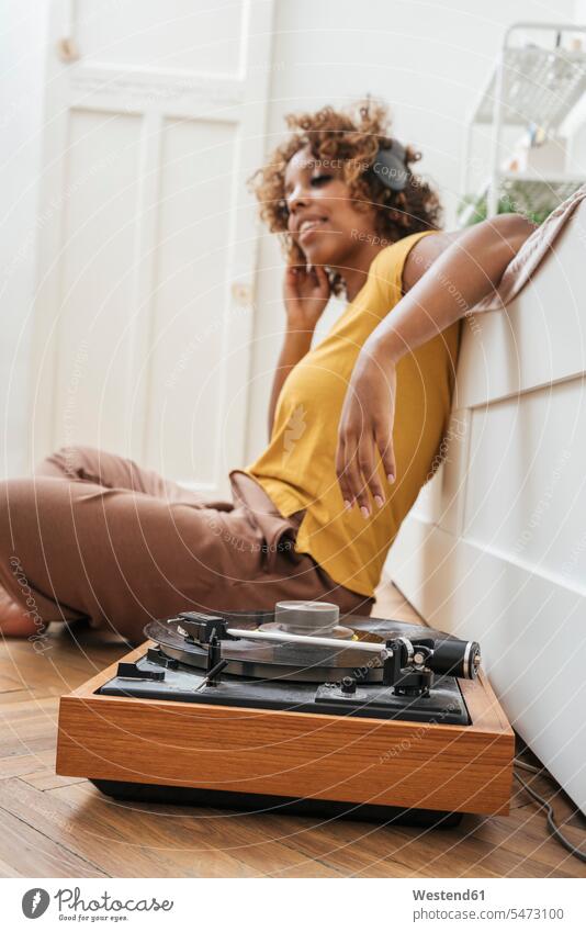 Young woman listening to music with headphones and record player at home human human being human beings humans person persons celibate celibates singles