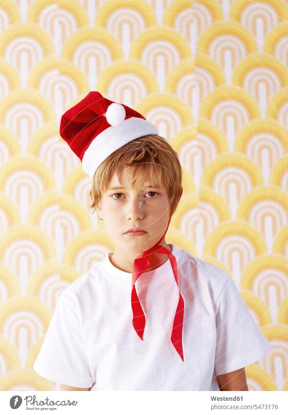 Portrait of boy in bad mood wearing Christmas cap portrait portraits boys males child children kid kids people persons human being humans human beings defiant