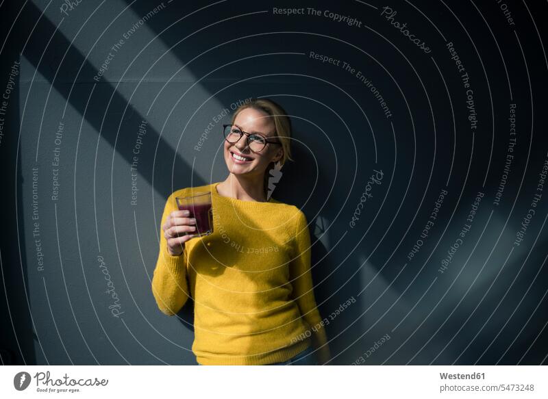 Woman in yellow pullover, holding glass of tea, enjoying the sun human human being human beings humans person persons caucasian appearance caucasian ethnicity