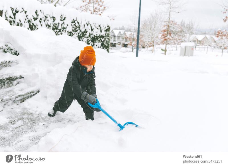 Little boy shoveling snow, Vancouver, Canada gloves seasons hibernal delight enjoyment Pleasant pleasure stand chilly Cold Temperature Cold Weather concentrate