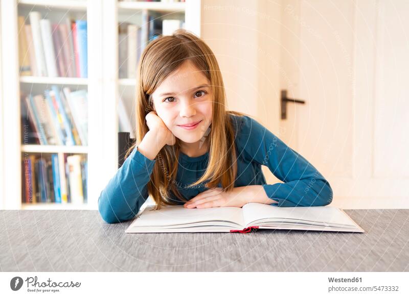 Girl reading a book smiling smile Joy enjoyment pleasure Pleasant delight bookworm learning Education books girl females girls child children kid kids people