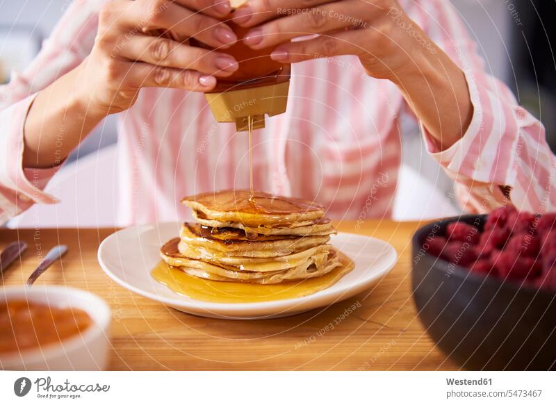 Young woman having sweet pancakes for breakfast, close up young women young woman Breakfast home at home Pancake Pancakes females Adults grown-ups grownups