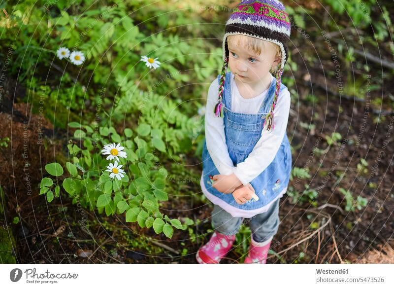 Portrait of sad little girl wearing knitted hat and denim dress outdoors baby girls female portrait portraits dresses babies infants people persons human being