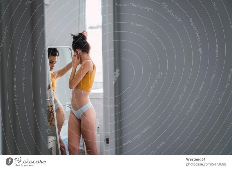 Young woman in underwear at home reflected in mirror stock photo
