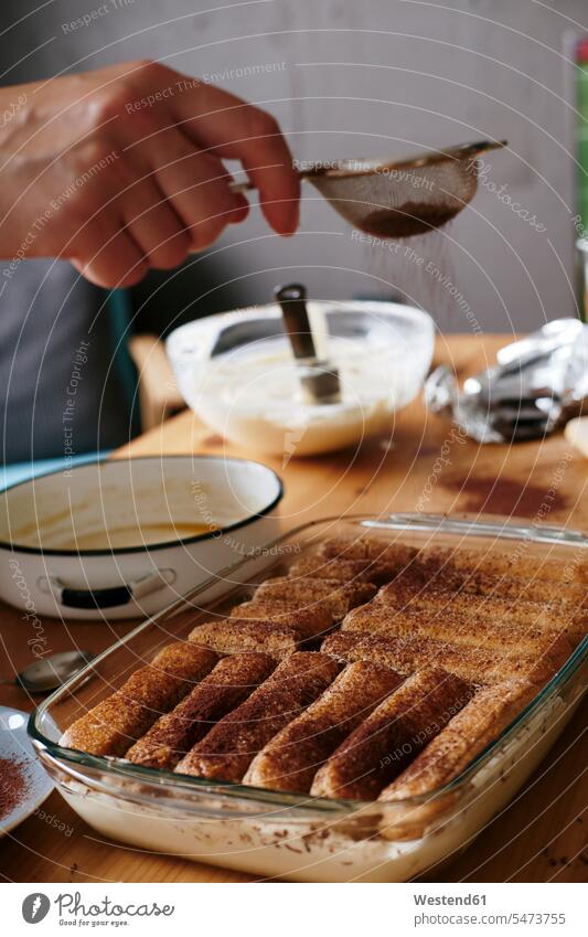 Woman's hand straining cocoa on Tiramisu human hand hands human hands cocoa powder Tirami su woman females women people persons human being humans human beings