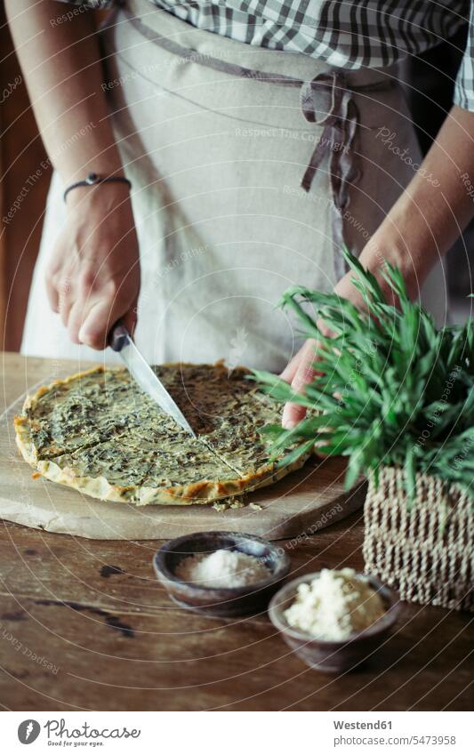 Young woman slicing homemade chickpea and herb cake pies cakes cutting tarragon Chickpea Chick Peas Cicer arietinum Chickpeas preparing Food Preparation