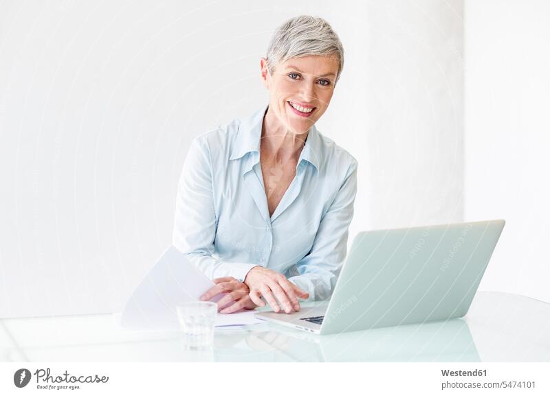 Portrait of smiling mature businesswoman working on laptop Career Woman Career Women smile At Work Laptop Computers laptops notebook portrait portraits