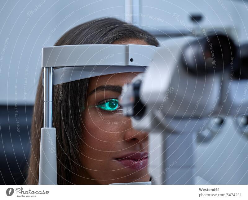 Optician, Young woman during eye test patient Optometry eyesight patients illness disease Sickness illnesses diseases healthcare and medicine medical