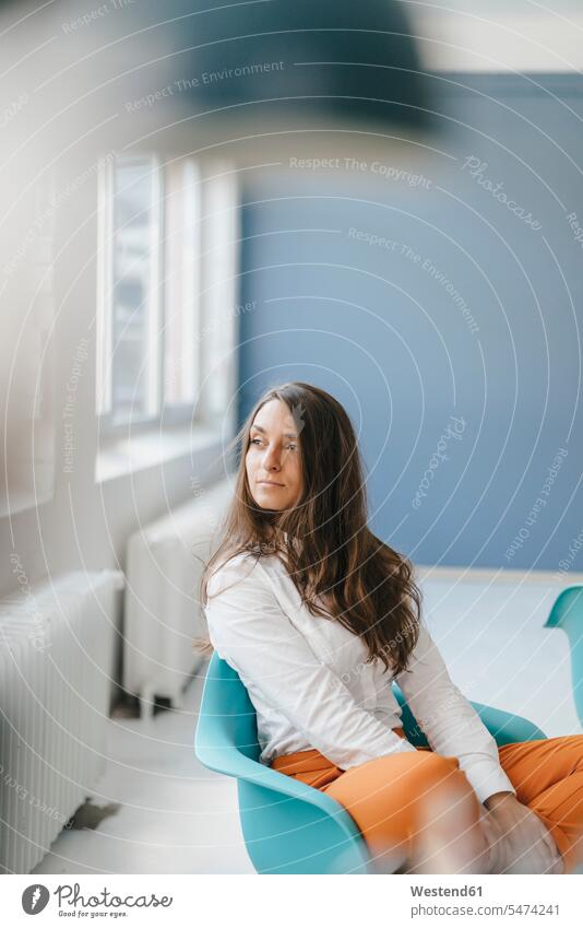 Young woman sitting in chair, looking out of window Mixed Race Person mixed-race Person mixed race ethnicity Seated confidence confident thinking Anticipation