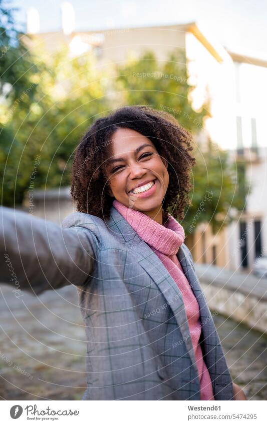 Portrait of laughing young woman raising hand females women Laughter portrait portraits Adults grown-ups grownups adult people persons human being humans