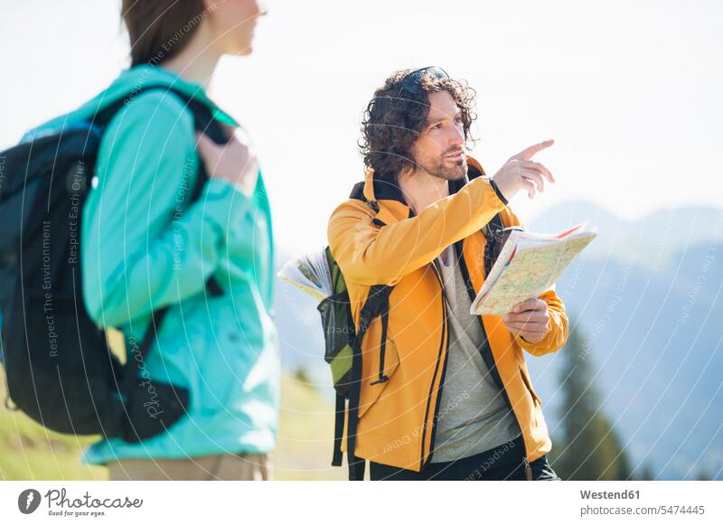 Hiking couple with map, Wallberg, Bavaria, Germany coat coats jackets discover discovering explore exploring free time leisure time directions Meadows