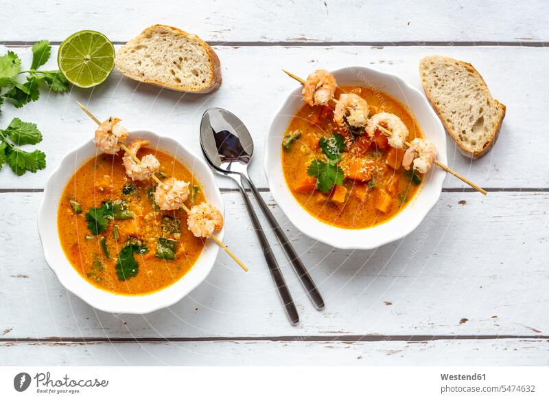 Two bowls of sweet potato soup with shrimps, coconut flakes and fresh coriander Bowl Bowls skewered spring onion spring onions green onion mashed puréed