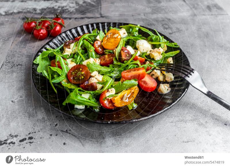 Plate of low carb vegetarian salad with arugula, tomatoes, nuts and Mozzarella cheese elevated view High Angle View High Angle Shot close-up close up closeup