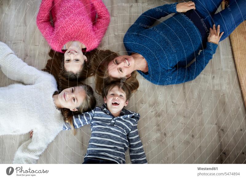 Happy family lying on the floor, laughing Security Secure casual leisure wear casual clothing casual wear casual clothes Casual Attire Enjoyment Amusement