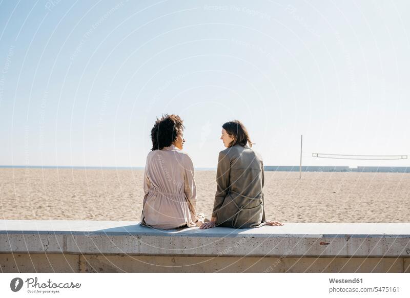 https://www.photocase.com/photos/5475161-back-view-of-two-friends-sitting-on-the-promenade-enjoying-leisure-time-photocase-stock-photo-large.jpeg