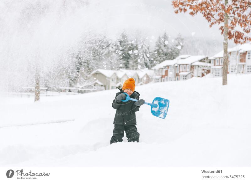 Laughing little boy shoveling snow, Vancouver, Canada gloves seasons hibernal delight enjoyment Pleasant pleasure Cheerfulness exhilaration gaiety gay glad