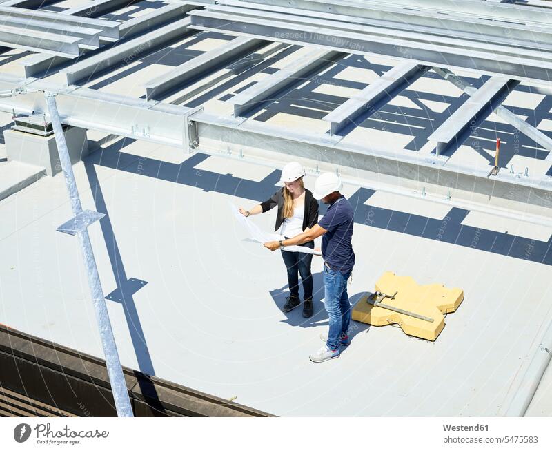Worker and architect looking at blueprint on construction site steel girder Steel Girders Building Site sites Building Sites construction sites female architect