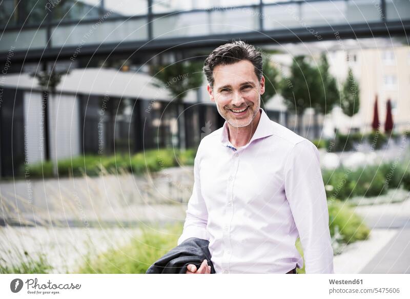 Portrait of smiling businessman outside office building smile portrait portraits office buildings Businessman Business man Businessmen Business men