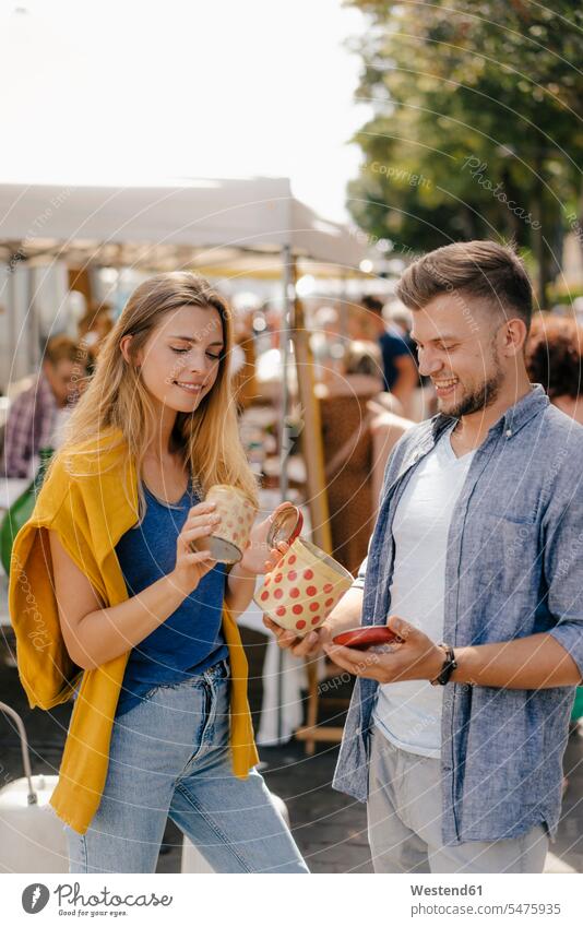 Belgium, Tongeren, young couple with tin cans on an antique flea market examining examine tins twosomes partnership couples antiques looking view seeing viewing