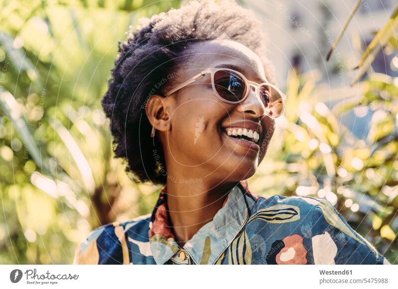 Portrait of happy young woman wearing sunglasses in garden Eye Glasses Eyeglasses specs spectacles Pair Of Sunglasses sun glasses relax relaxing seasons