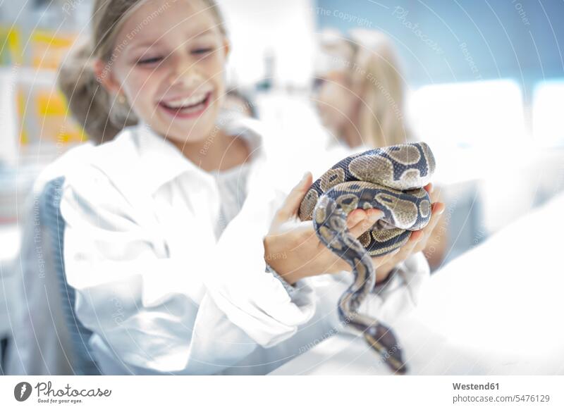 Happy schoolgirl in science class holding snake serpentes serpents snakes female pupils School Girl schoolgirls School Girls happiness happy schools reptile