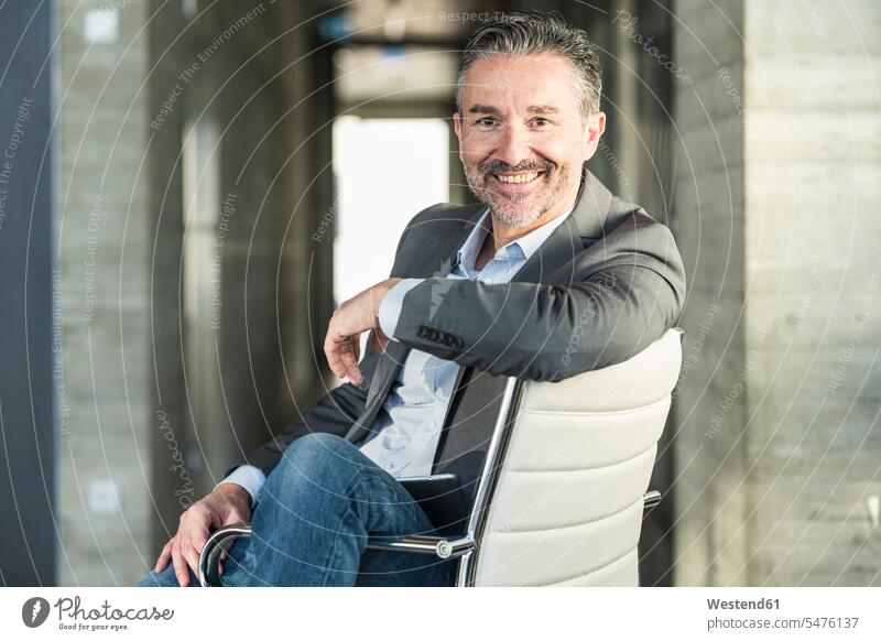 Portrait of a smiling mature businessman sitting on chair in office Occupation Work job jobs profession professional occupation business life business world