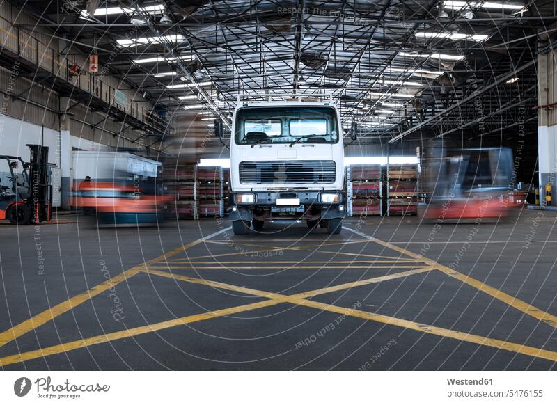 Parked truck in warehouse and moving forklifts forklift truck forklift trucks loading industrial hall shop floor factory hall industrial buildings factories