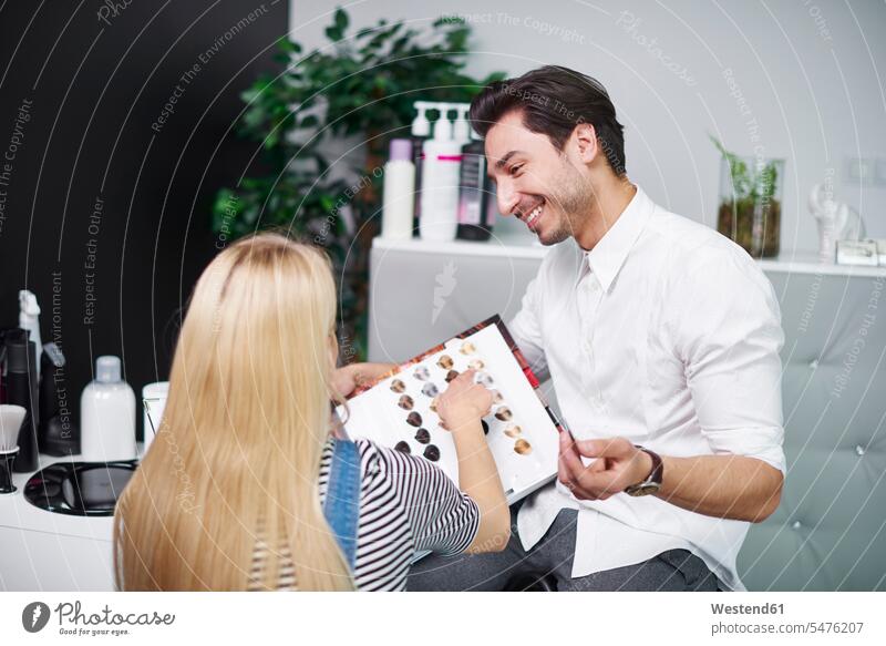 Woman choosing hair color from palette in hair salon hairdresser hair-dresser hair-dressers hairdressers haircutter haircutters woman females women hair colour