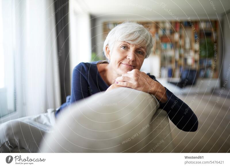 Contemplating senior woman relaxing while sitting on sofa color image colour image indoors indoor shot indoor shots interior interior view Interiors day