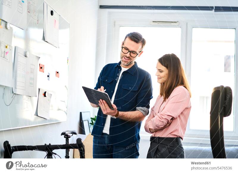 Two colleagues at whiteboard sharing tablet in office digitizer Tablet Computer Tablet PC Tablet Computers iPad Digital Tablet digital tablets share white board