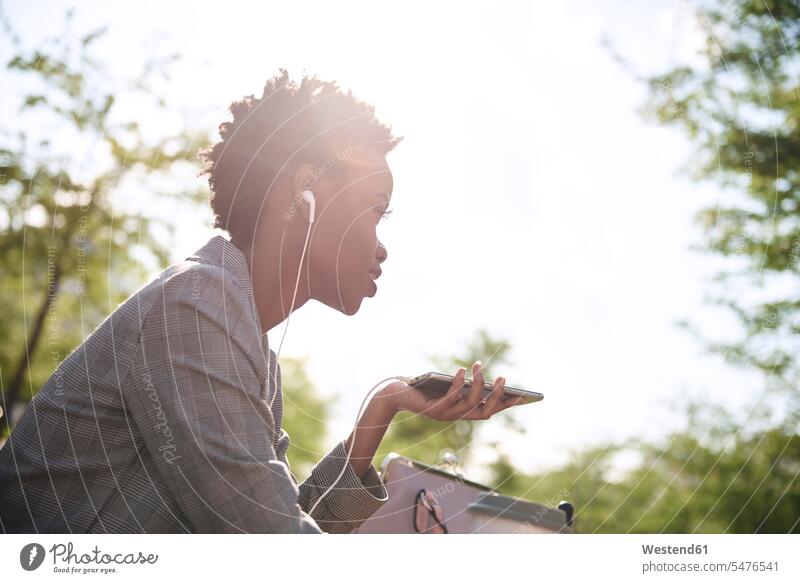 Businesswoman with earphones and smartphone at backlight ear phone ear phones Smartphone iPhone Smartphones on the phone call telephoning On The Telephone