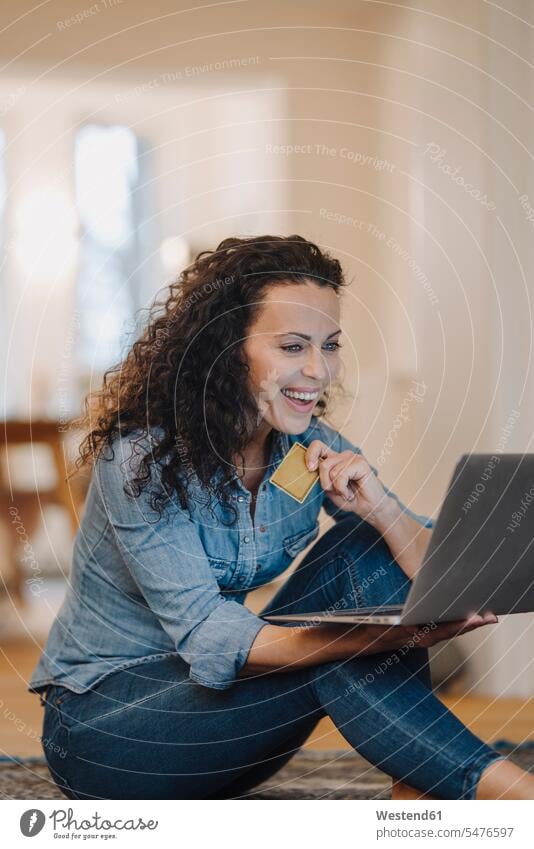 Woman making an online payment with credit card, using laptop human human being human beings humans person persons caucasian appearance caucasian ethnicity