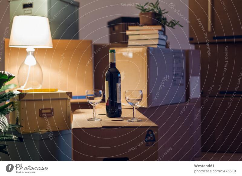 Wine bottle and glasses on cardboard box in an empty room in a new home move moving Moving Home indoor indoor shot indoor shots interior interior view Interiors