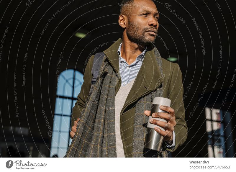 Stylish man with reusable cup getting out of the train station business life business world business person businesspeople Business man Business men Businessmen