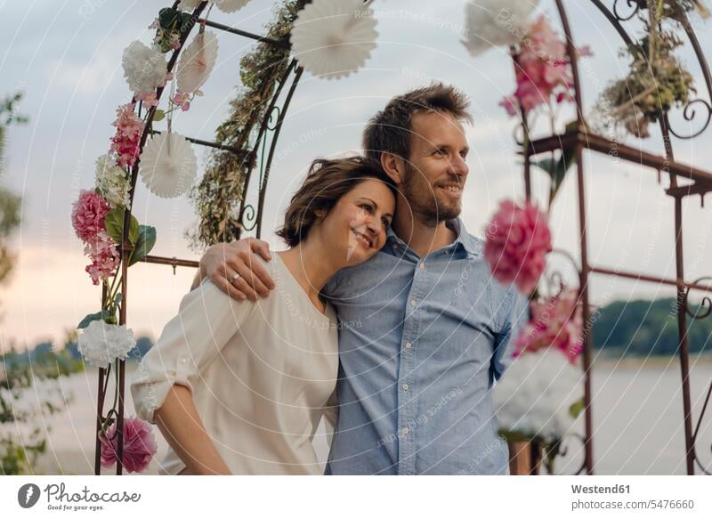 Happy couple embracing under wedding arch happiness happy twosomes partnership couples Wedding Arch embrace Embracement hug hugging people persons human being