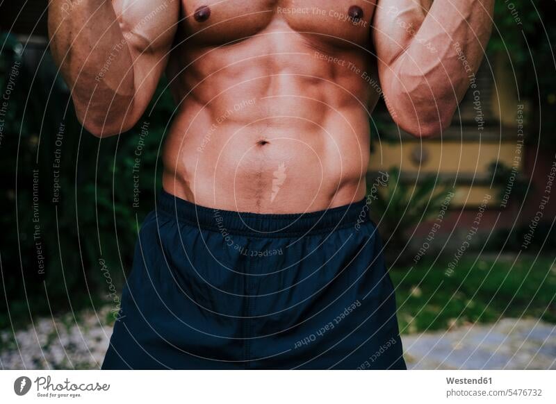 Close-up of shirtless muscular man exercising in yard color image colour image Spain outdoors location shots outdoor shot outdoor shots day daylight shot