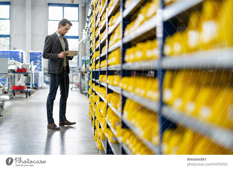 Businessman using tablet in storehouse of a factory Business man Businessmen Business men digitizer Tablet Computer Tablet PC Tablet Computers iPad