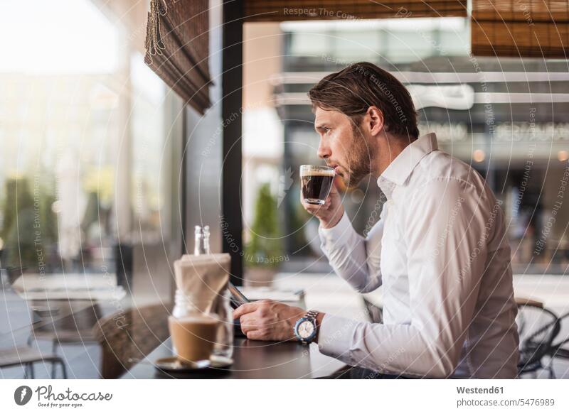 Businessman with tablet in a cafe drinking coffee from glass Coffee Business man Businessmen Business men digitizer Tablet Computer Tablet PC Tablet Computers