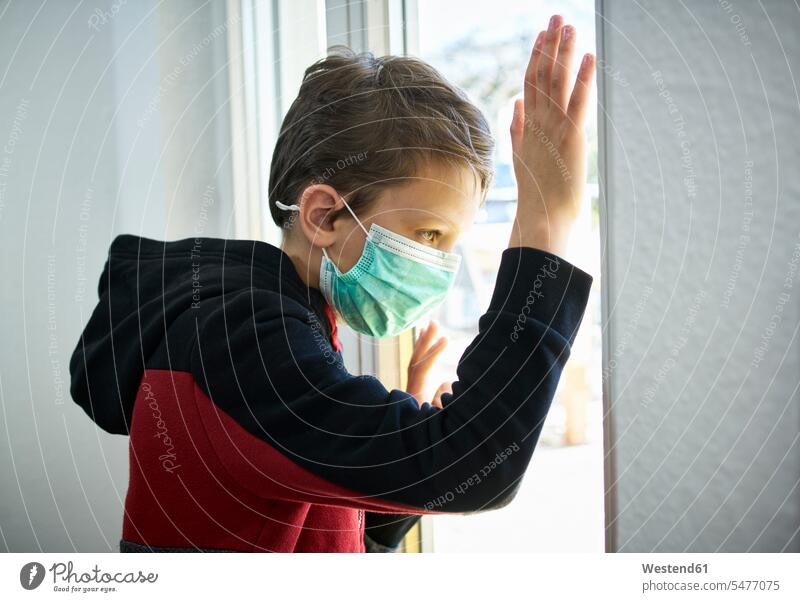 Sad boy with mask looking out of window windows solitary reclusive reclusively pessimistic contemplative pensively Reflective thoughtful aspirations Crave