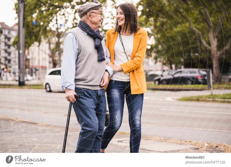 Adult Grandbabe Assisting Her Grandfather Strolling With Walking Stick A Royalty Free