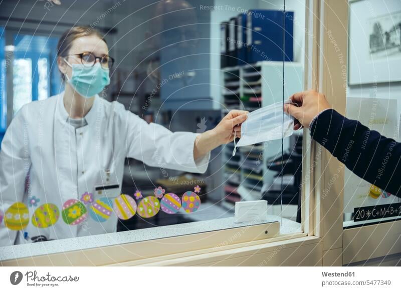 Employee at reception desk of hospital ward handing over mask to visitor health healthcare Healthcare And Medicines medical medicine disease diseases ill