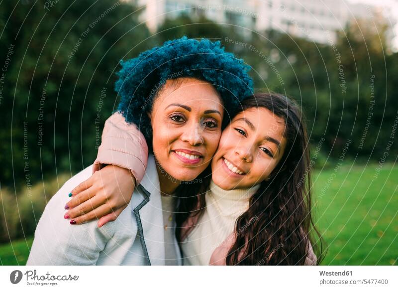 Smiling daughter embracing mother in park color image colour image Portugal leisure activity leisure activities free time leisure time casual clothing