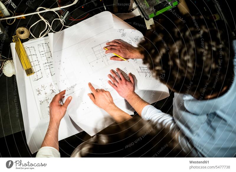 Two colleagues working on a construction plan together Occupation Work job jobs profession professional occupation architects business life business world