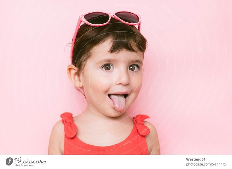 Portrait of little girl sticking out tongue in front of pink background human human being human beings humans person persons caucasian appearance