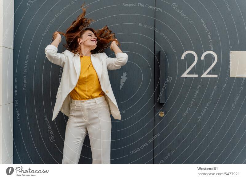 Businesswoman in white pant suit, standing in front of entrance door Occupation Work job jobs profession professional occupation business life business world