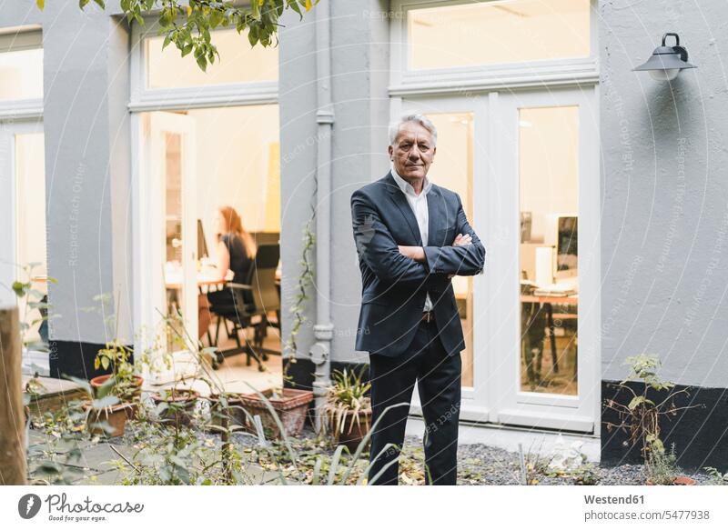 Senior businessman standing in backyard of his office with arms crossed Occupation Work job jobs profession professional occupation business life business world