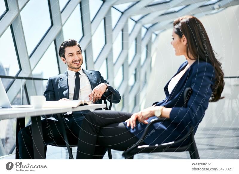 Businesswoman and businessman talking at desk in modern office businesswoman businesswomen business woman business women speaking contemporary Businessman