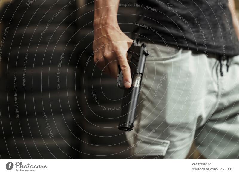 Close-up of man holding a pistol gun guns pistols men males shooting range weapon arms weapons Adults grown-ups grownups adult people persons human being humans