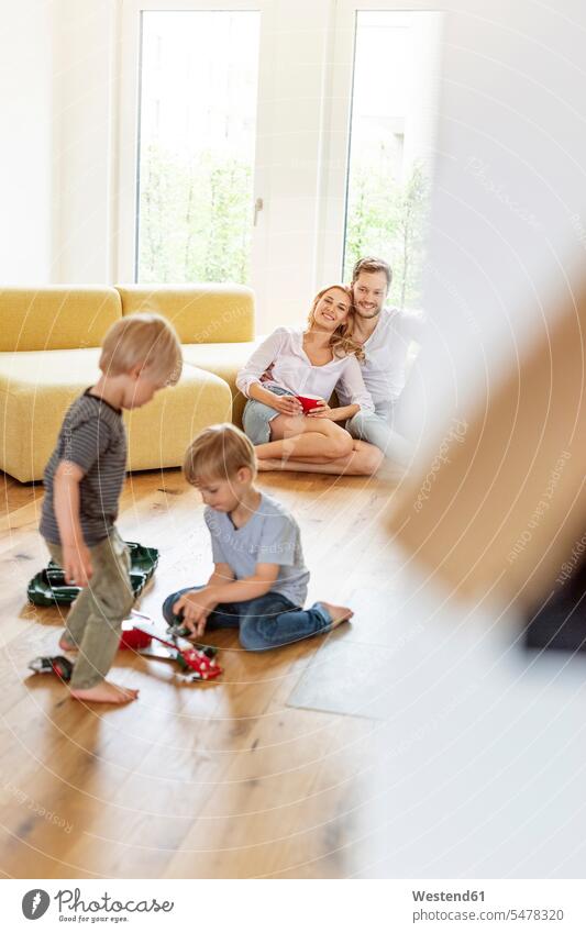 Happy family with two sons in living room of their new home human human being human beings humans person persons caucasian appearance caucasian ethnicity
