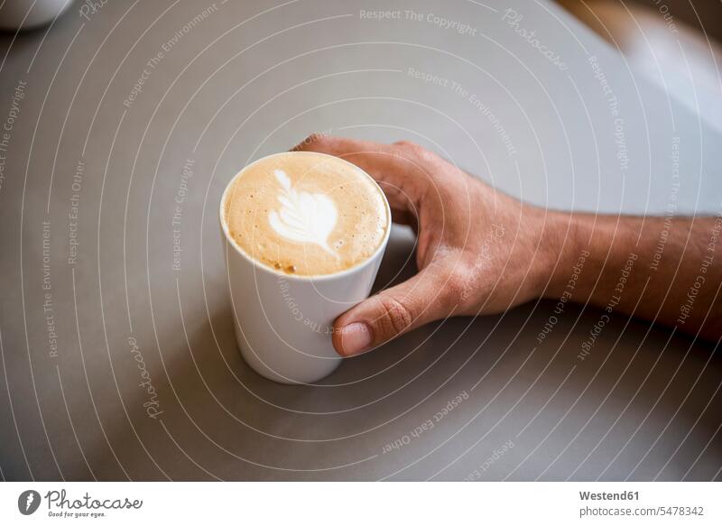 Hand and cup of cappuccino in a cafe Cappuccino cappucino milk froth hand human hand hands human hands Cup Cups White Coffee Milky Coffee Coffee with Milk Drink